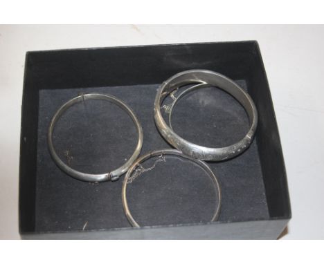 Three silver and one white metal bangle