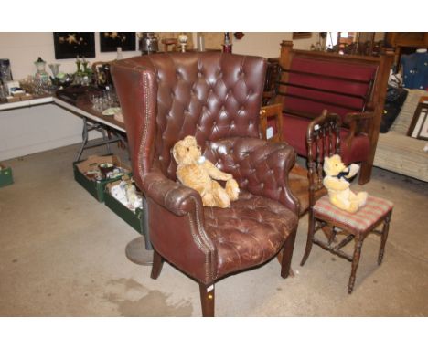 A brown leather button back upholstered armchair