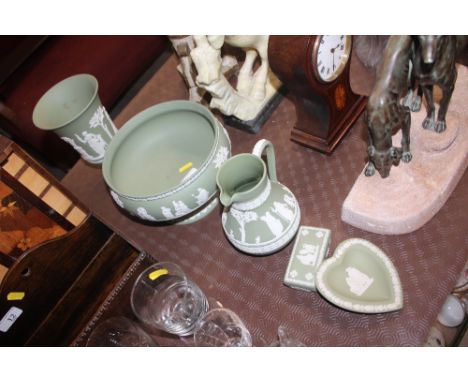 Five items of Wedgwood green jasperware china to include a vase, pedestal bow, jug, trinket box and a pin dish 