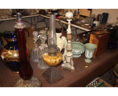 A cast iron based oil lamp with mottled glass reservoir