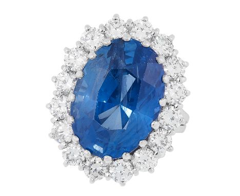 A CEYLON NO HEAT SAPPHIRE AND DIAMOND CLUSTER RING set with an oval cut sapphire of 13.73 carats in a border of round cut dia