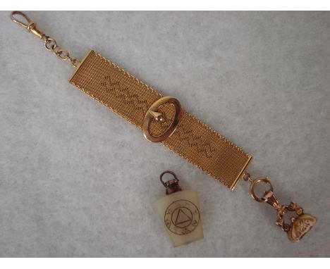 A 9ct gold fob attached to a pendant in the form of a ribbon with buckle and conforming suspension clip, 12.2g and a jade mas