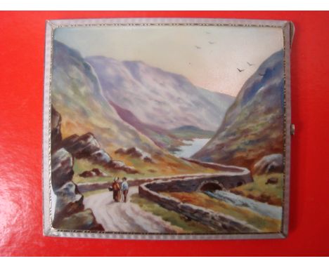 A George V silver cigarette case of rectangular form, the top enamel decorated with two figures on a Lakeland track within an