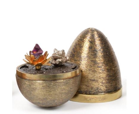 Stuart Devlin: A Silver Gilt Surprise Egg, London 1972, the interior featuring a frog sat on a lily pad beside an amethyst fl