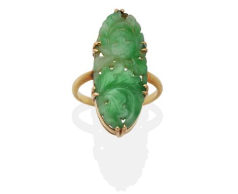 A Jade Ring, a carved and pierced oval plaque depicting flowers and leaves, in a double claw setting, finger size L1/2 see il