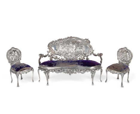 An Edwardian Silver Miniature Sofa and Pair of Side Chairs, William Comyns, London 1902, the backs decorated with courting co