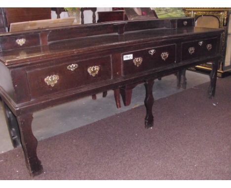 An early 18th Century oak dresser base with 3 large drawers plus 2 small shelf drawers. Has it's original brass handles and e