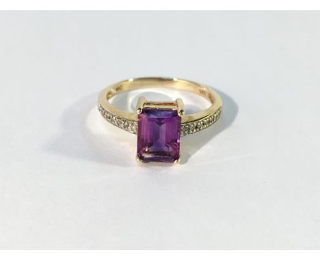 An amethyst ring with diamond shoulders in gold