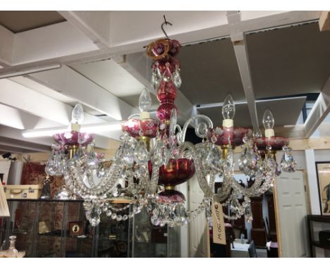 A 10 arm glass chandelier with ruby embellishments and crystal droppers