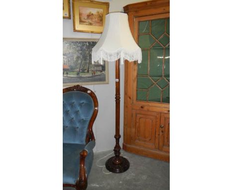 A carved base standard lamp with shade