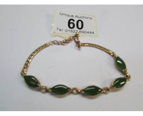 A yellow metal and jade bracelet