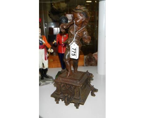 A Victorian/Edwardian metal figure of an urchin playing a flute