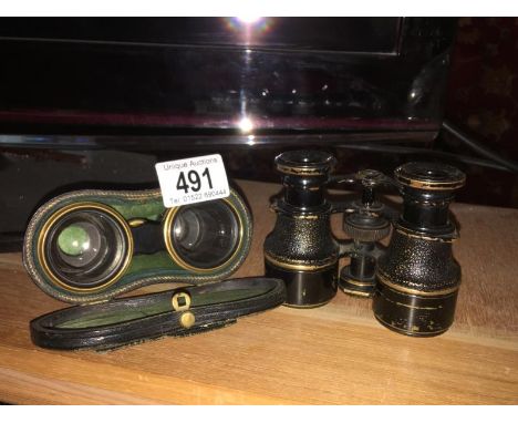 A small pair of field binoculars with compass and a cased pair of binoculars