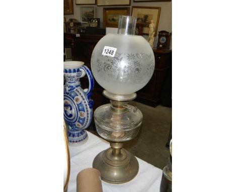 An oil lamp on brass base with glass font and acid etched shade