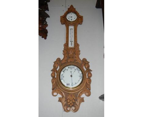 An Edwardian oak aneroid barometer with clock & porcelain faces, one decorated with fruit