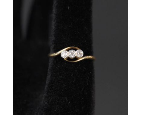 An 18ct gold three stone diamond ring, size R (as found, middle diamond damaged)