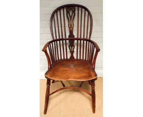 A yew wood high stick backed Windsor elbow chair on hooped base
