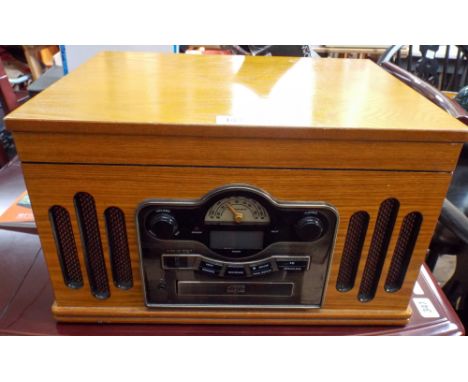 A radio, CD player, record deck in an old box style cabinet 