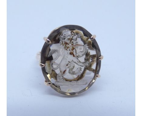 Intaglio panel ring, the smoky quartz carved with a lion rampant, claw set in 9ct rose gold. Ring size M 1/2.     Stone has m