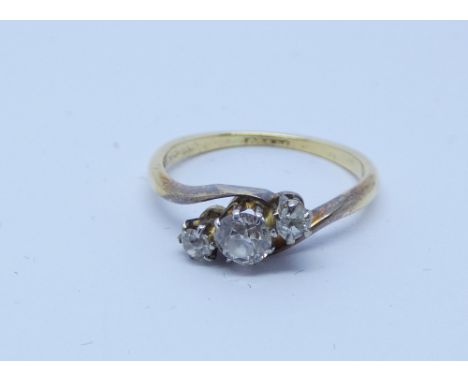 Three stone diamond ring in a cross over design on 18ct shank, ring size K