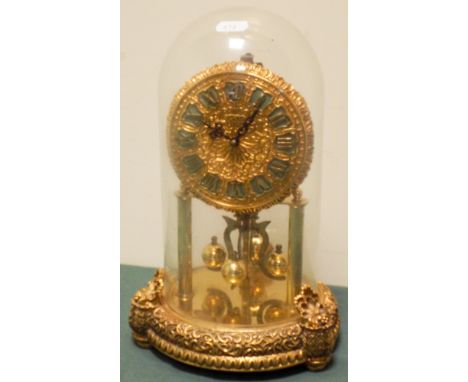 A Decorative brass 400 day clock under a glass dome 