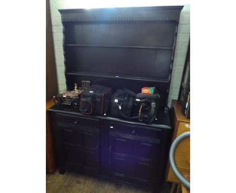 A very dark oak, antique style dresser, close panel back above two draws and cupboards under 
