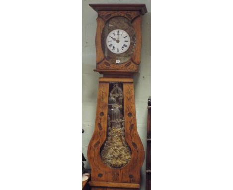 A French long case clock in oak case with floral carved front, a circular enamel and brass dial with striking movement 