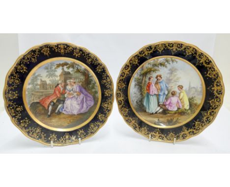 A pair of Meissen cabinet plates, hand painted with classical pastoral scenes within rich blue and gilt borders and blue cros