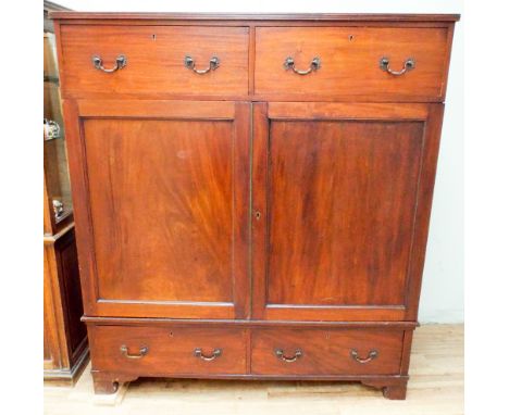 A Victorian mahogany two door cupboard with interior shelf with two large drawers over and under with brass fall handles 57" 