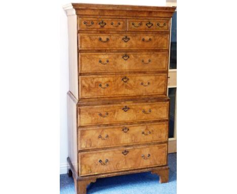 An early 18th century walnut veneered continental Chest on Chest; the cavetto cornice above an arrangement of two half-width 