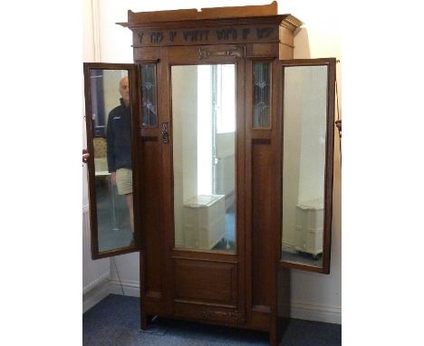 A good early 20th century Arts and Crafts style and period single oak Wardrobe; the cornice above an applied frieze legend: "