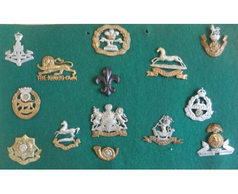 Fourteen Yorkshire and Lancastrian infantry cap badges mounted on a display board: Alexandra, the Princess of Wales's Own (Yo