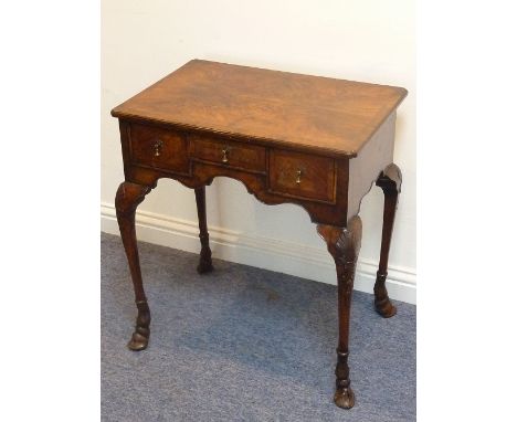 An unusual early 18th century walnut Lowboy; the quarter-veneered crossbanded and feather-banded top above an arrangement of 