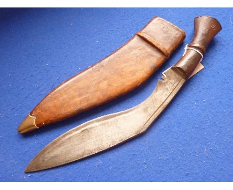 An early 20th century Gurkha's kukri, patinated wooden handle and within hand-stitched patinated brown leather Scabbard, the 