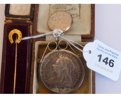 A small gold-coloured circular Locket, a cased Stick Pin modelled as a horseshoe and a 19th century silver Pendant modelled f