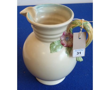 A circa 1940s Clarice Cliff pottery jug in good condition; the handle decorated in high relief with two flowers,leaves etc., 