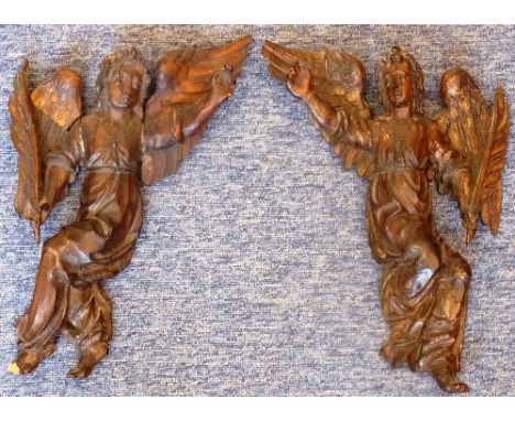 An opposing pair of early-style carved wood Angel Scribes, each angel open-winged and holding a large feather quill, (damage 