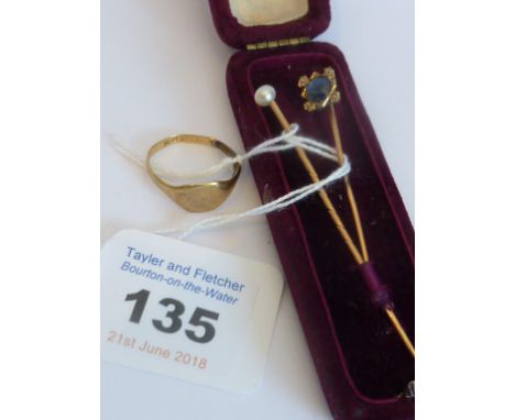 A rose gold Stick Pin surmounted with a pearl; one other yellow metal example centred with a sapphire and small white stones 