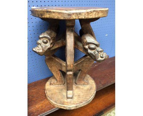 Cameroon style carved stool table, with 4 carved heads below at seat of 30cm diameter. 43cm High. 