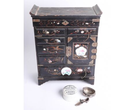 A Chinese black lacquered table cabinet, a silver salt pot and a silver shoe pin cushion, and a pot lid from 'W. Woods Chemis