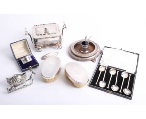 A boxed silver napkin ring, set of six silver teaspoon, pair of silver backed brushes, two circular silver photo frames and a