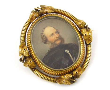 An oval Victorian memorial portrait brooch of a military gentleman, in a yellow metal frame with hair insert to reverse, the 