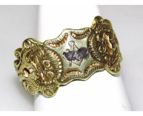 A Masonic related dress ring, of shaped scroll outline, with etched Masonic compass and a part engraved band, unmarked, proba