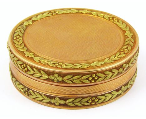 A George III 18ct gold circular box, with bi-colour engine turned decoration with applied leaf wreath borders, hallmark Londo