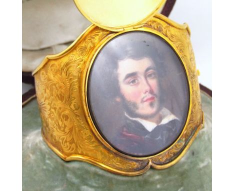 A highly decorated Victorian hinged bangle, with an enamelled front piece covering a portrait, probably on ivory, of a young 