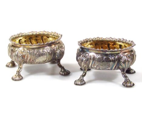 A matched pair of George III silver gilt open salts, probably D.& R. Hennell, the crested gadrooned bodies raised on quadrupl