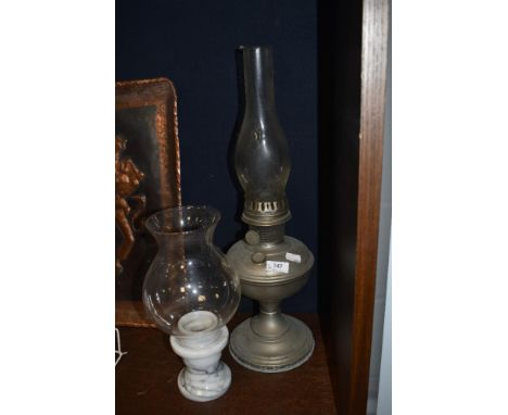 An early 20th century table top oil lamp with chimney and a marble based candle holder with shade.