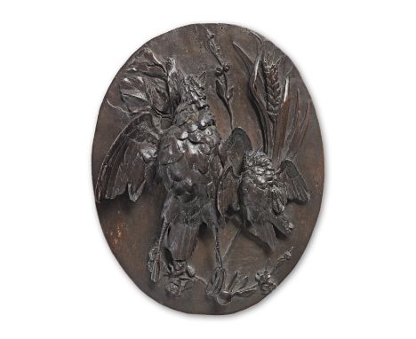 A carved limewood oval plaque, in the manner of Grinling Gibbons (1648-1721)Carved with a pair of hanging gamebirds, before a