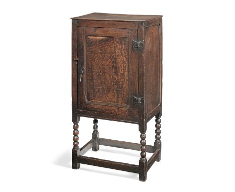 A small Charles II joined oak single-door enclosed-cupboard, circa 1670Have a one-piece top board, the panelled door enclosin