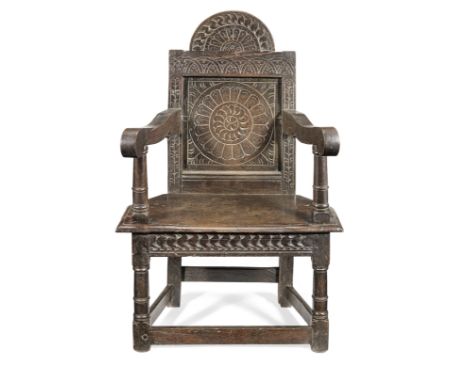 A James I joined oak panel-back 'caqueteuse' open armchair, Salisbury, circa 1625Having a distinctive semi-circular cresting 